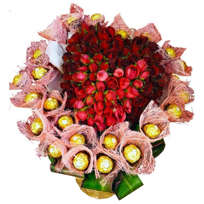 A basket of Red Roses in the shape of a heart surrounded by Chocolates